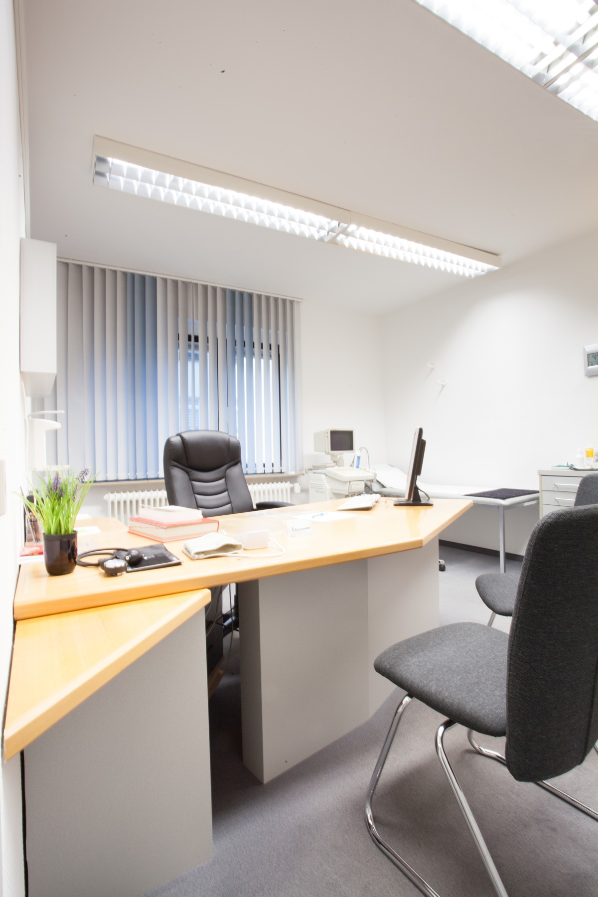 Sprechzimmer mit Schreibtisch und Untersuchungsplatz in unseren früheren Praxisräumen